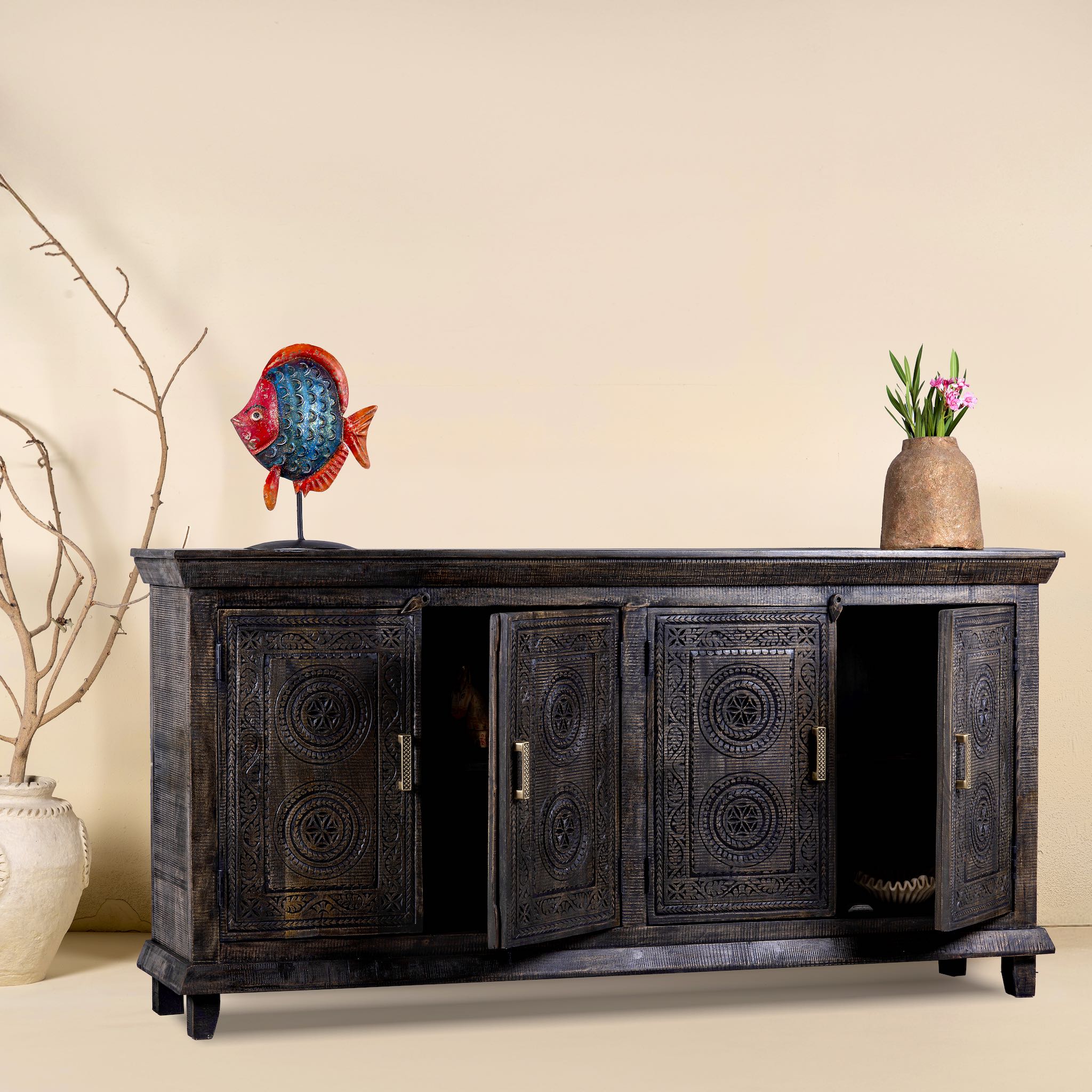 Side angle with open doors of a handcrafted wood carved sideboard in black mango wood with four doors, versatile for bedroom furniture or living spaces, 180 × 40 × 90 cm.