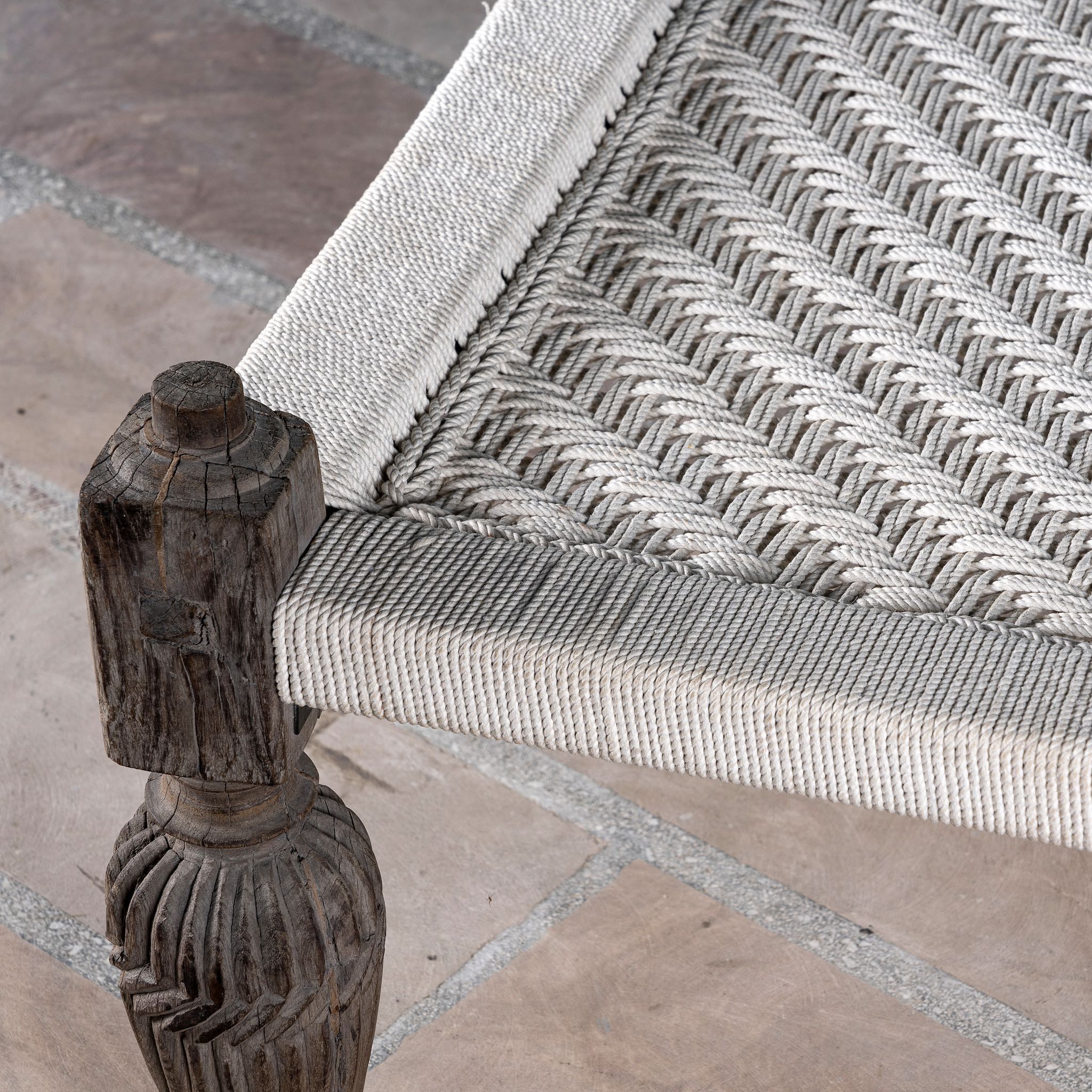 Close up of a handwoven Indian Charpai bed with reclaimed teak frame and carved legs; perfect for Indian home decor, 170 × 105 × 45 cm.