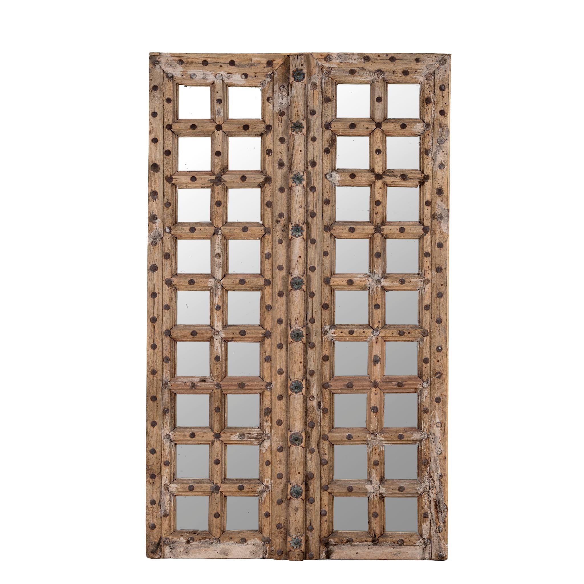 White background image of a wooden door mirror made from antique teak, part of our Indian home decor collection with original carvings and iron accents.