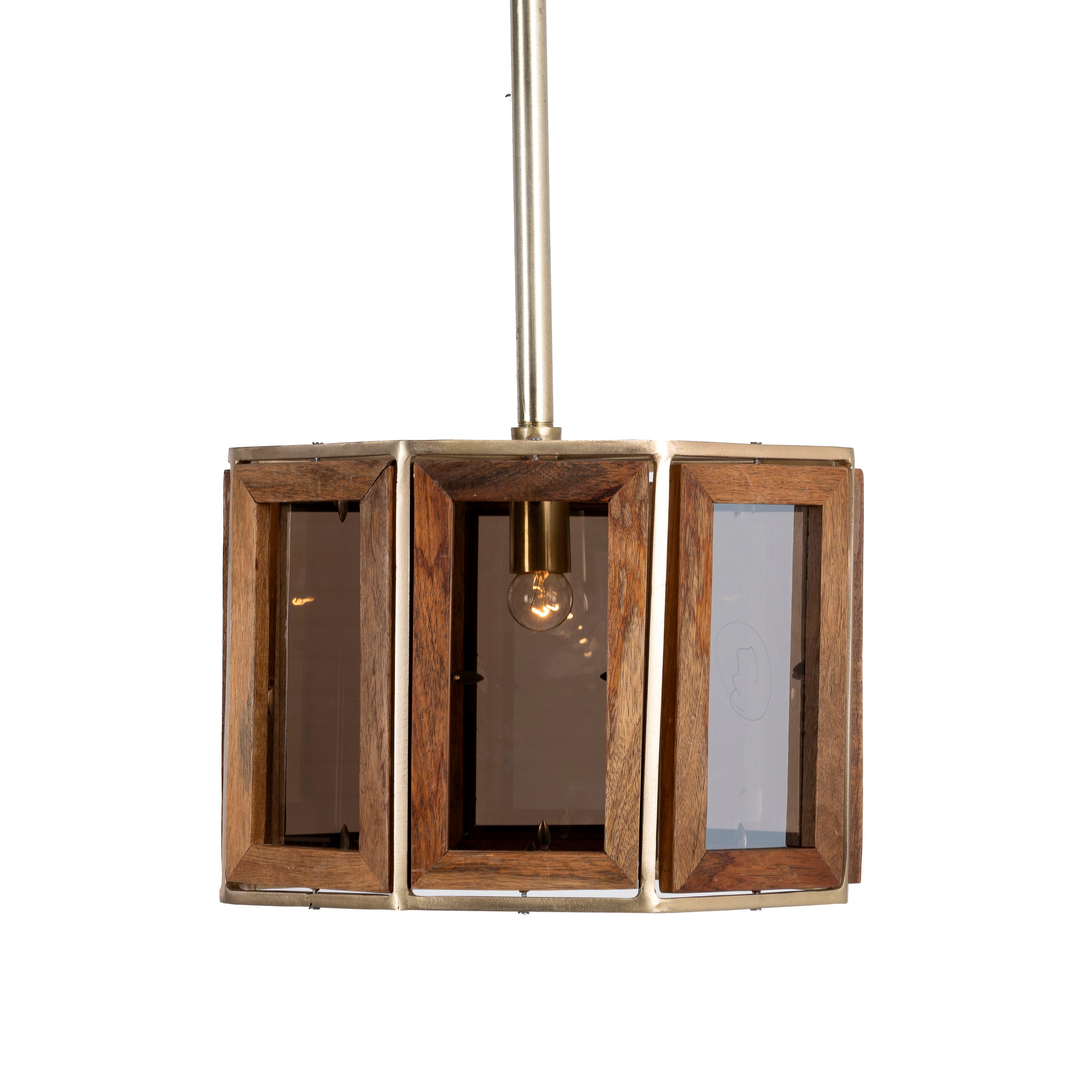 An octagon-shaped pendant lamp with a mango wood frame and antique brass cladding, featuring three visible light fixtures.