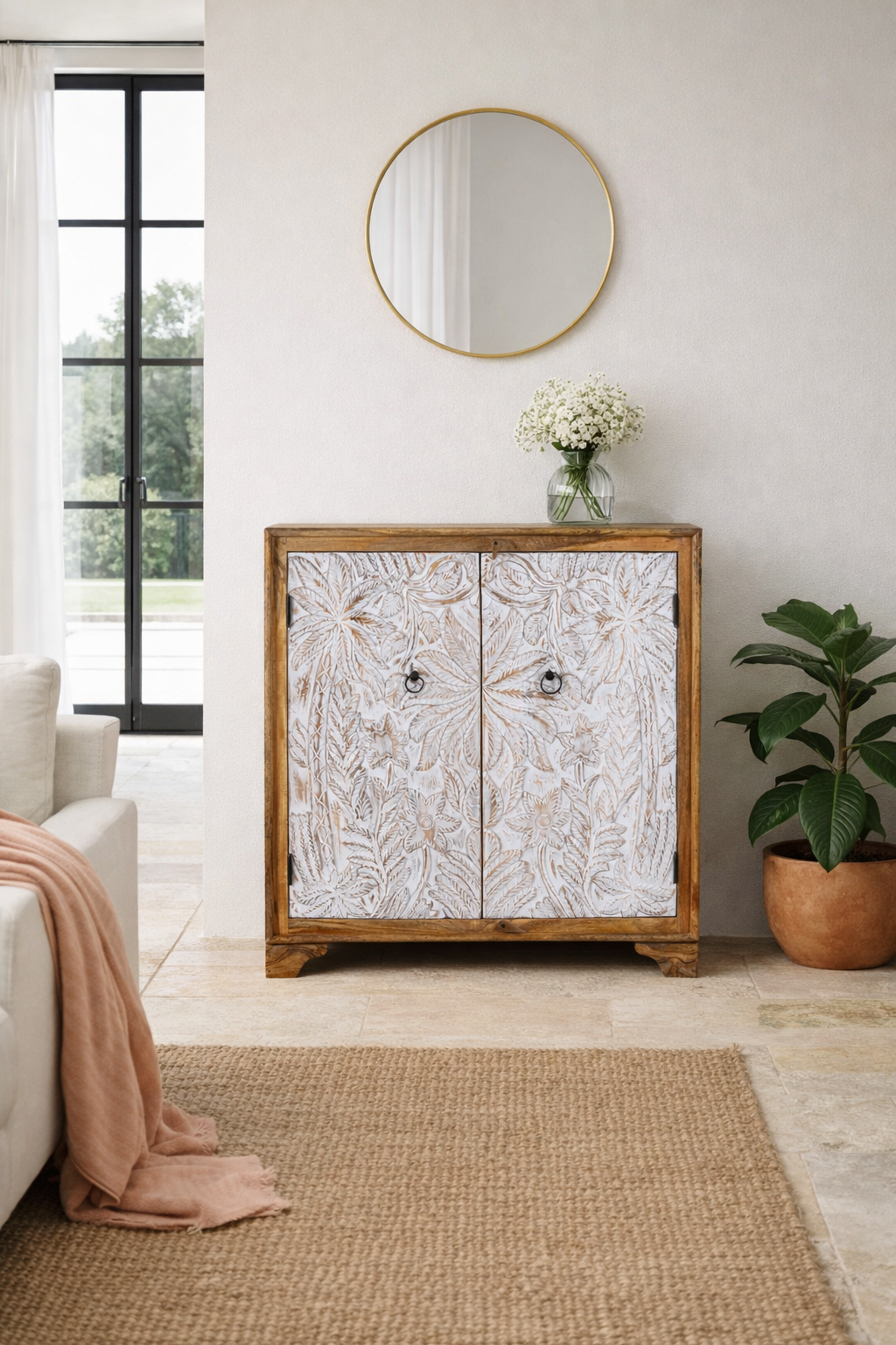 Lifestyle imagination of a hand-carved mango wood cupboard Utkarsh with whitewashed doors featuring palm tree and botanical motifs. A Mediterranean-inspired piece of Indian furniture combining artisan detail with practical storage.