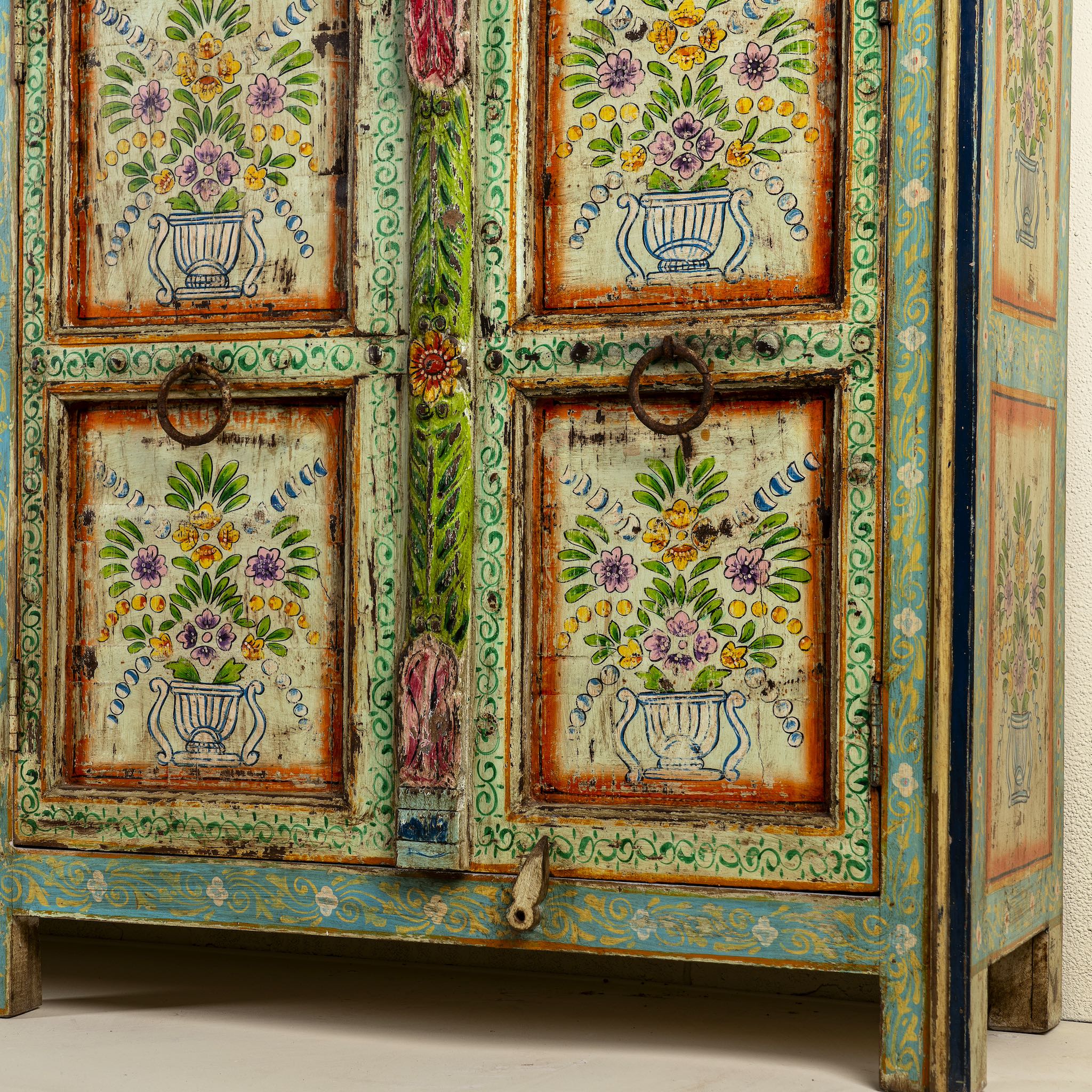 Close up image of the leg part of a reclaimed wood sideboard with hand painted floral motifs and distressed finish; artisanal storage furniture for bohemian interiors, 170 × 40 × 104 cm.
