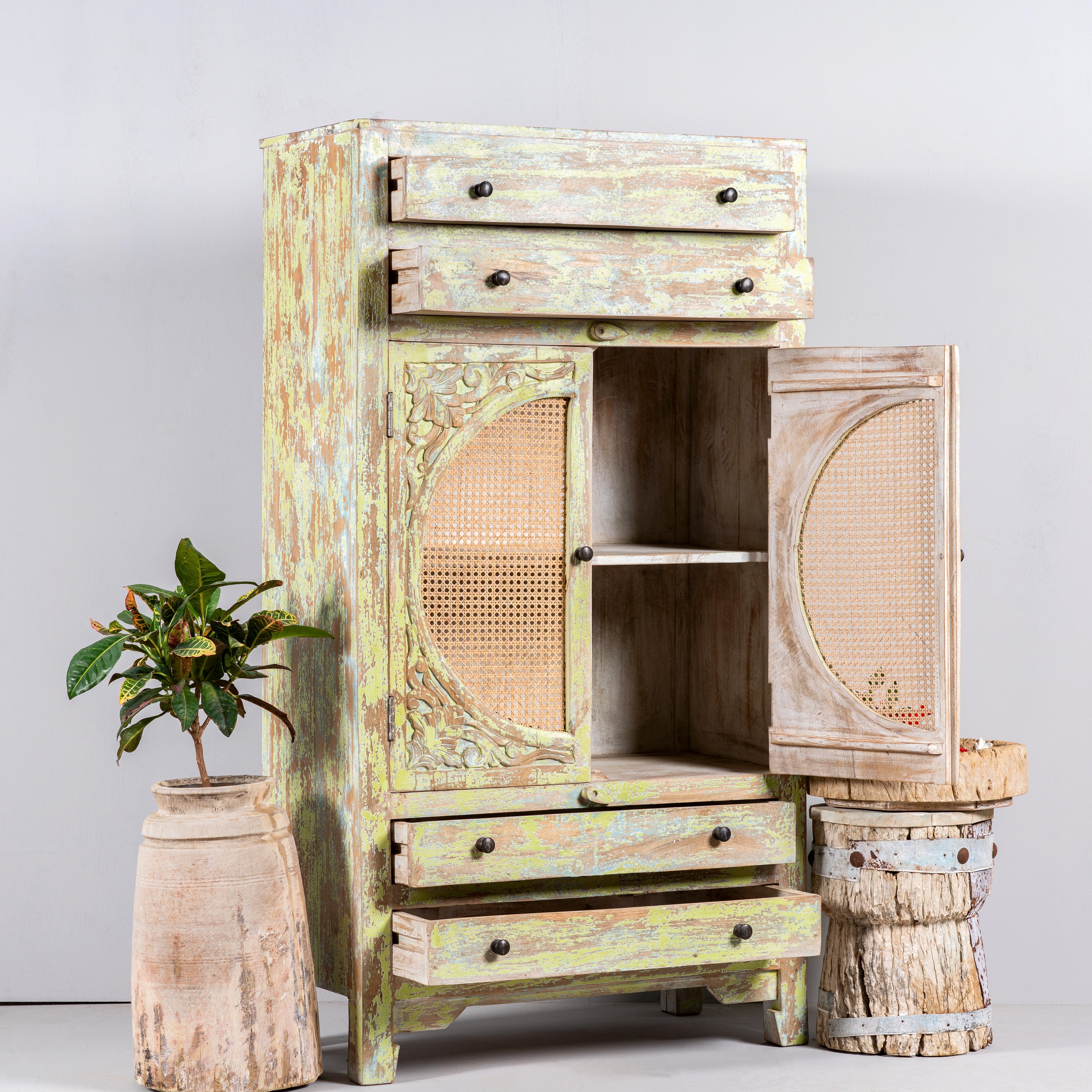 Open door image of a green-washed mango wood cabinet with floral carvings, rattan door inserts, versatile living room furniture, 80 × 148 × 40 cm.