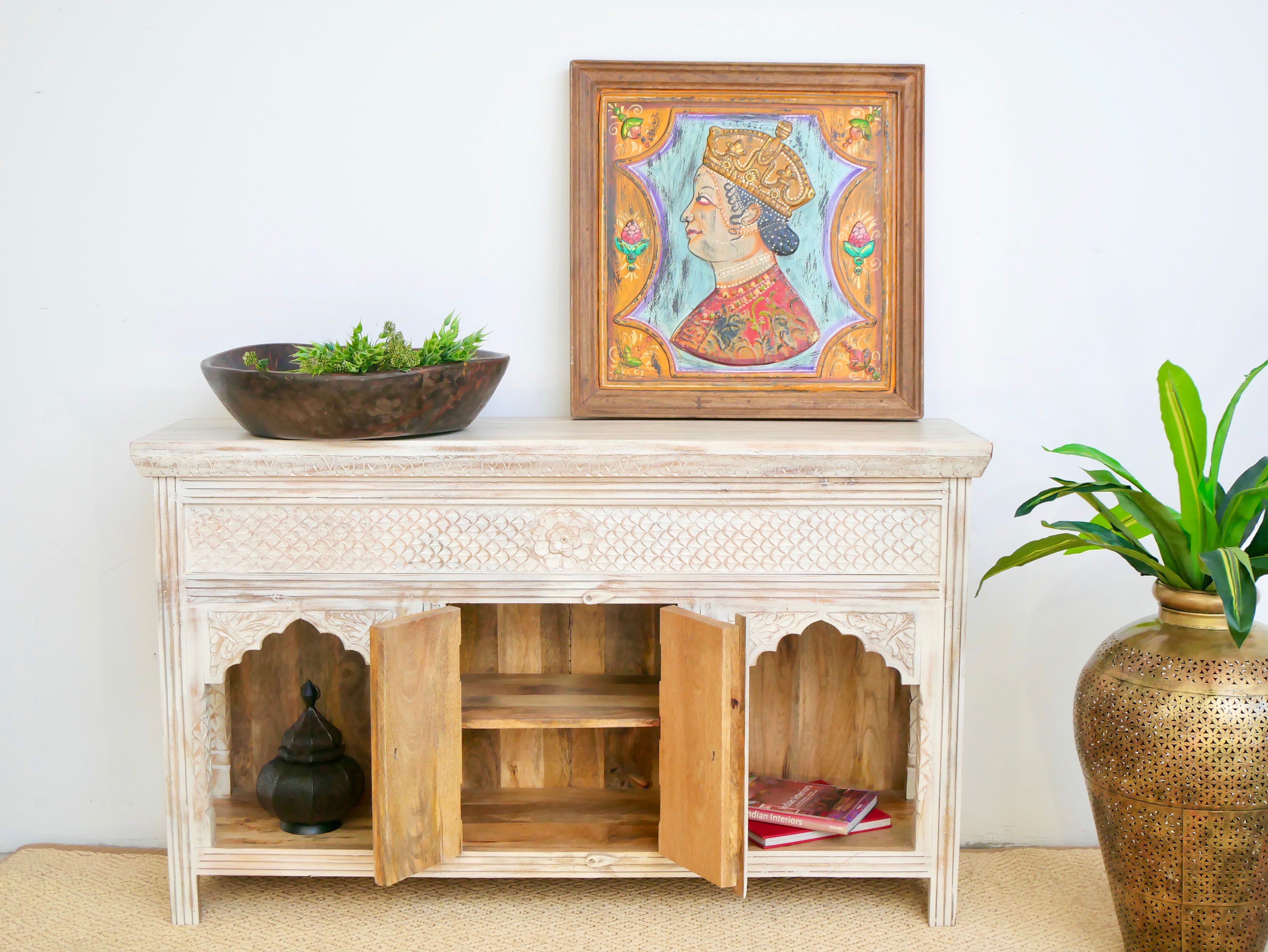 Open door image of a mango wood console table with Oriental hand-carved front; Mediterranean style carved console table with two storage compartments, 150 × 90 × 40 cm.
