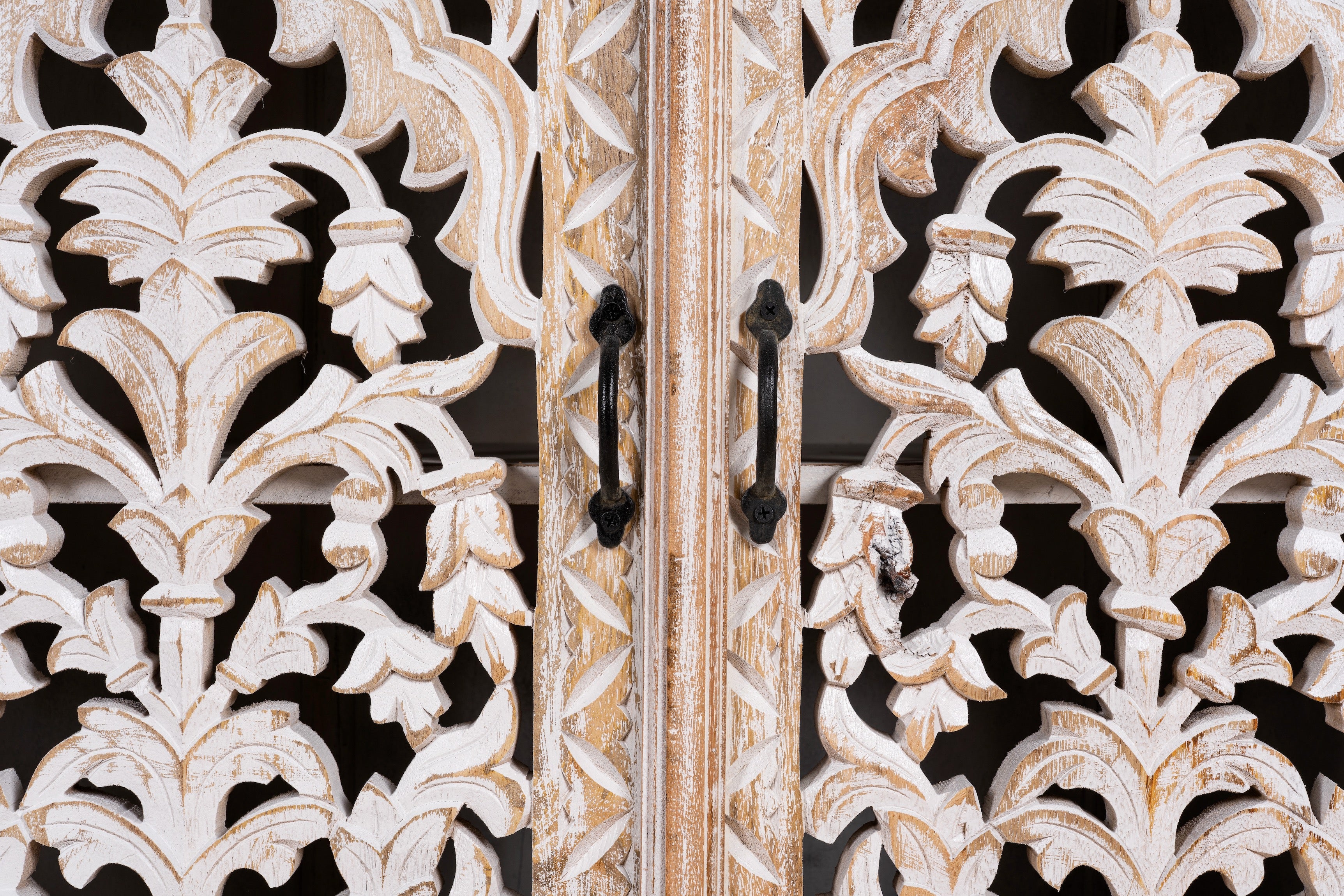 Close up image of a hand-carved whitewashed mango wood sideboard with intricate floral detailing, perfect for a boho chic living room or vintage-inspired interior.