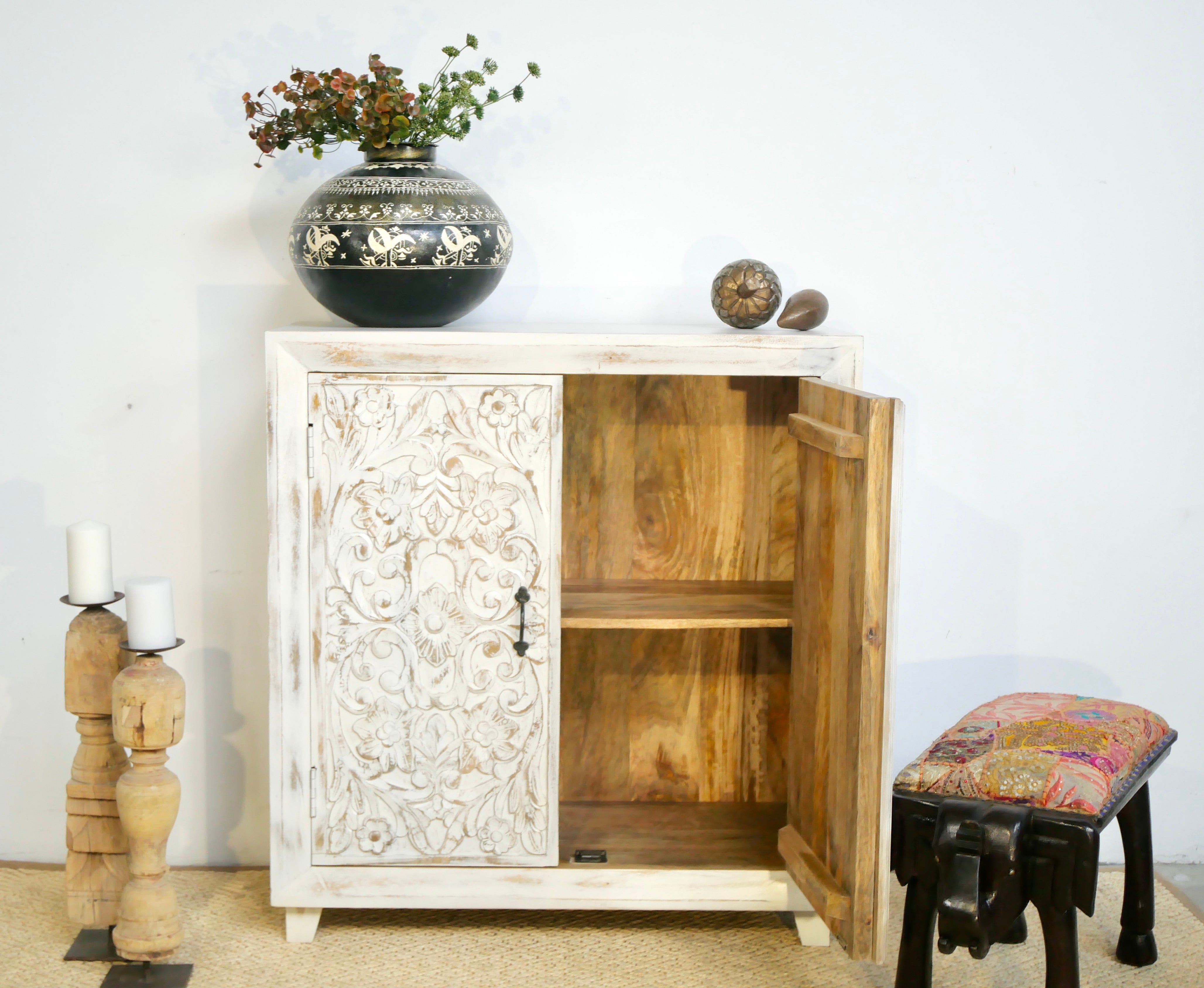 Image with open door of a white washed wooden cabinet made from mango wood with hand-carved Indian floral patterns, rustic Mediterranean-style furniture, 90 × 97 × 40 cm.