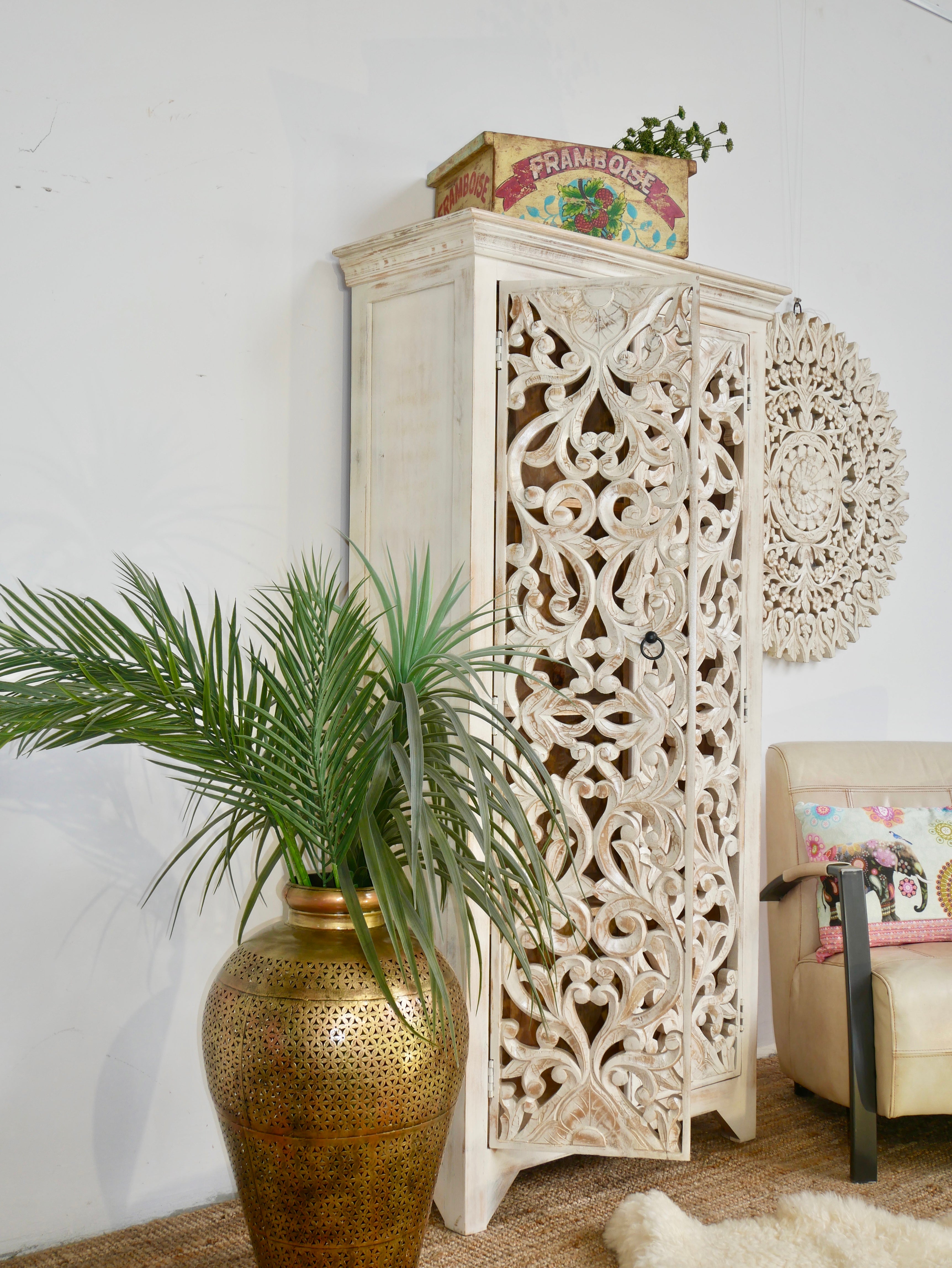 Side angle image of a hand-carved mango wood cabinet with floral and geometric motifs in white-washed finish – carved wooden furniture with Mediterranean-inspired design.