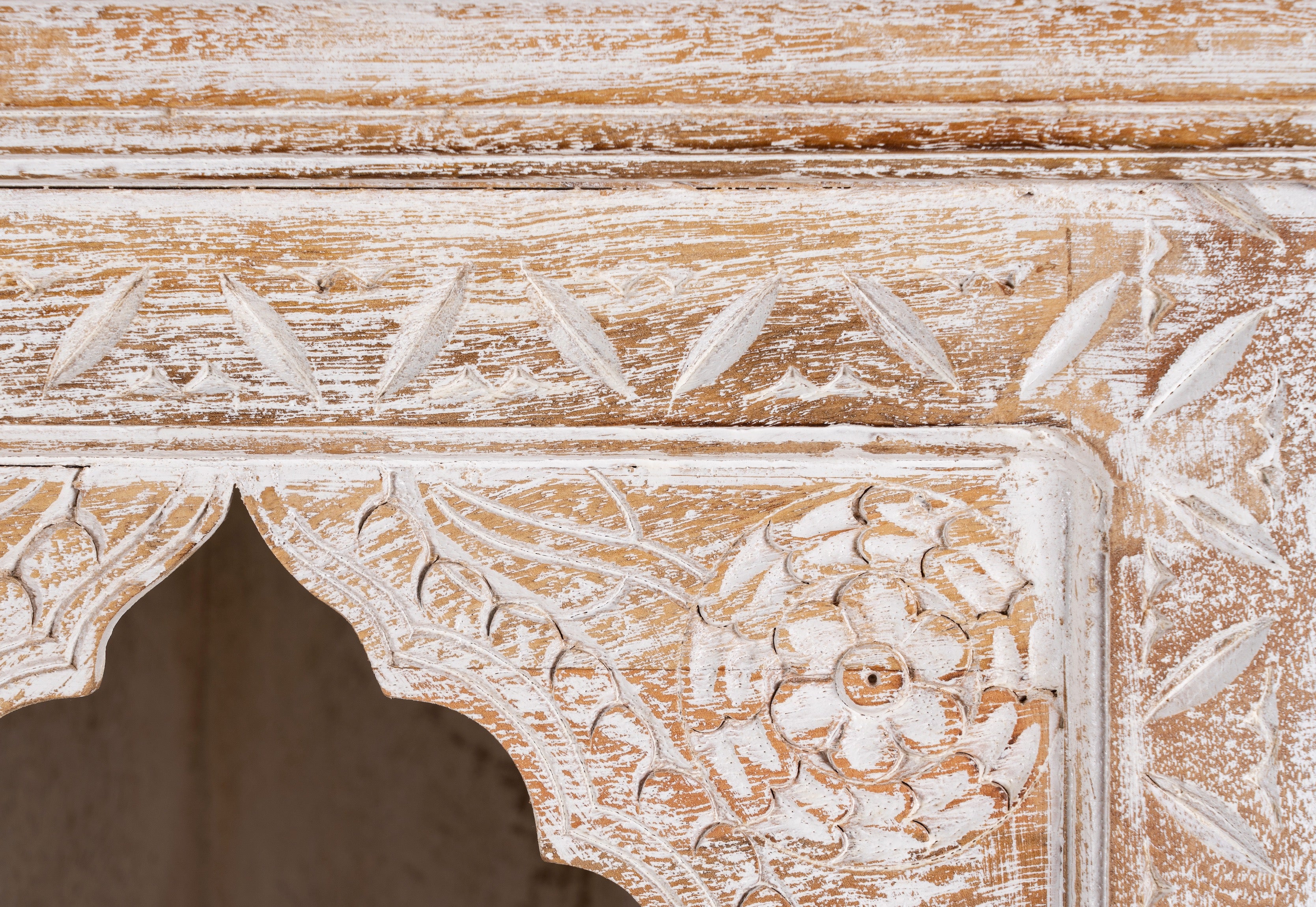 Close up image of a hand-carved mango wood bookshelf with oriental detailing and natural wood finish – carved wooden furniture and vertical shelving for refined, rustic interiors.