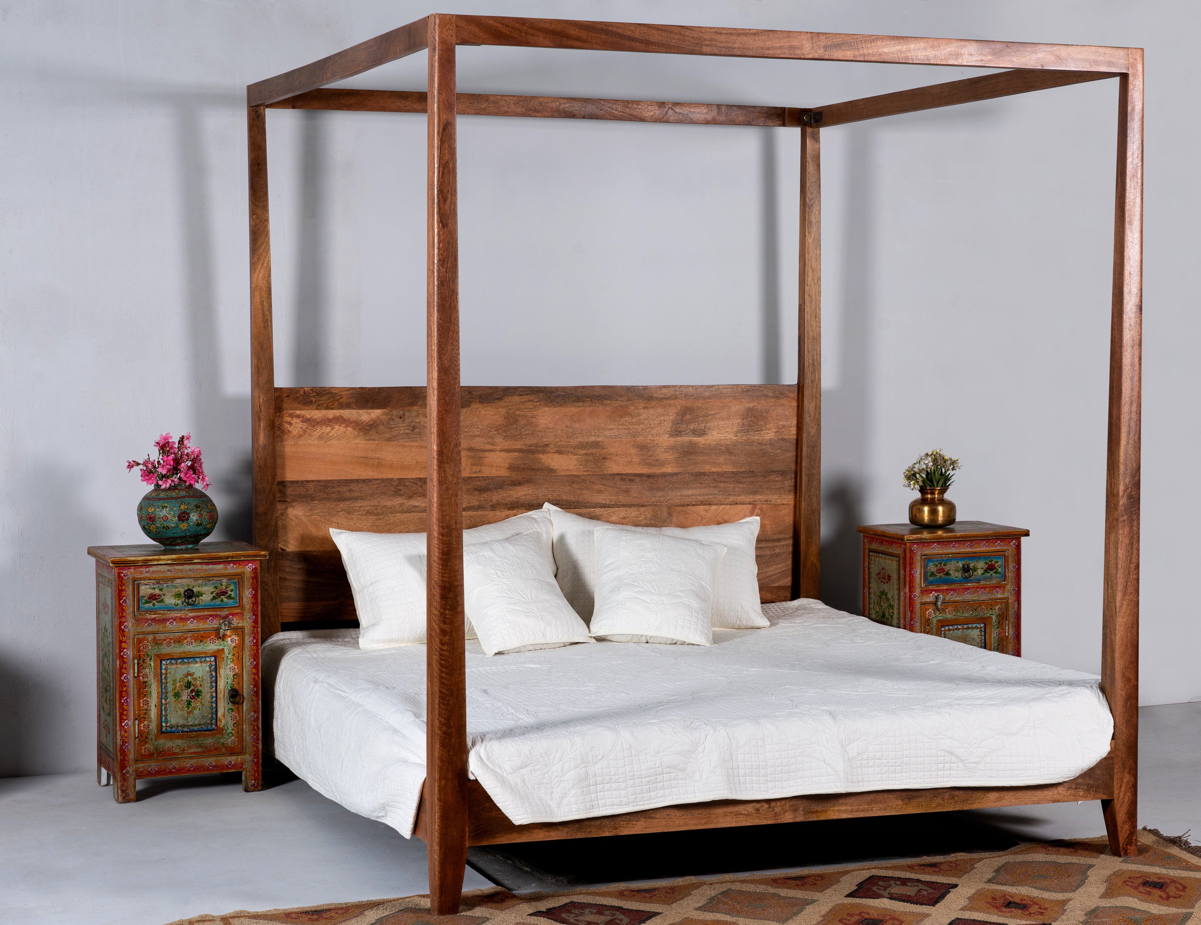 Lifestyle image of a set of two hand painted bedside tables with floral motifs; sustainable furniture made of recycled wood, 45 × 35 × 70 cm.