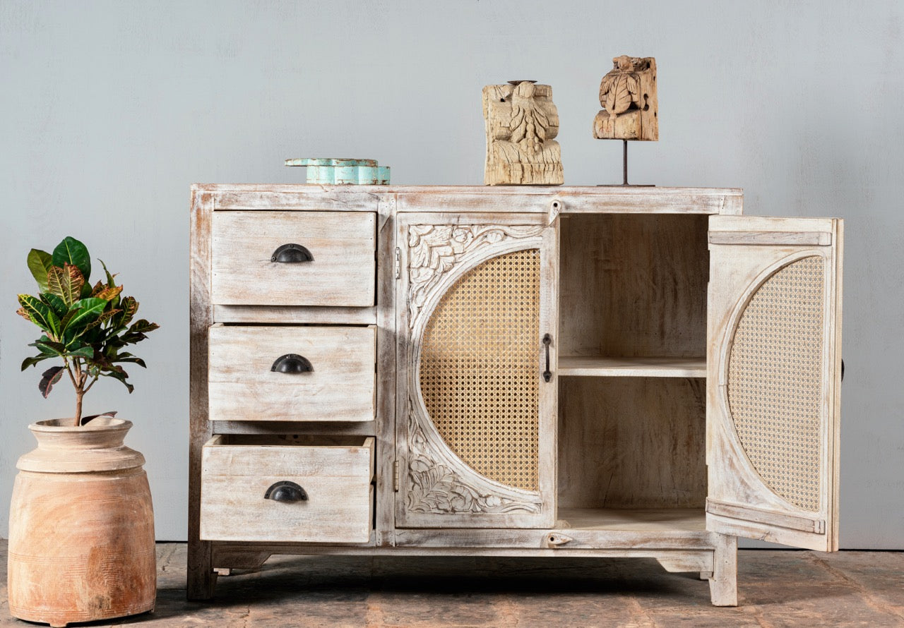Open door image of a handcrafted mango wood dresser with floral carvings and rattan cane inserts, bohemian interior and rattan furniture style, whitewashed finish, 120 × 40 × 92 cm.