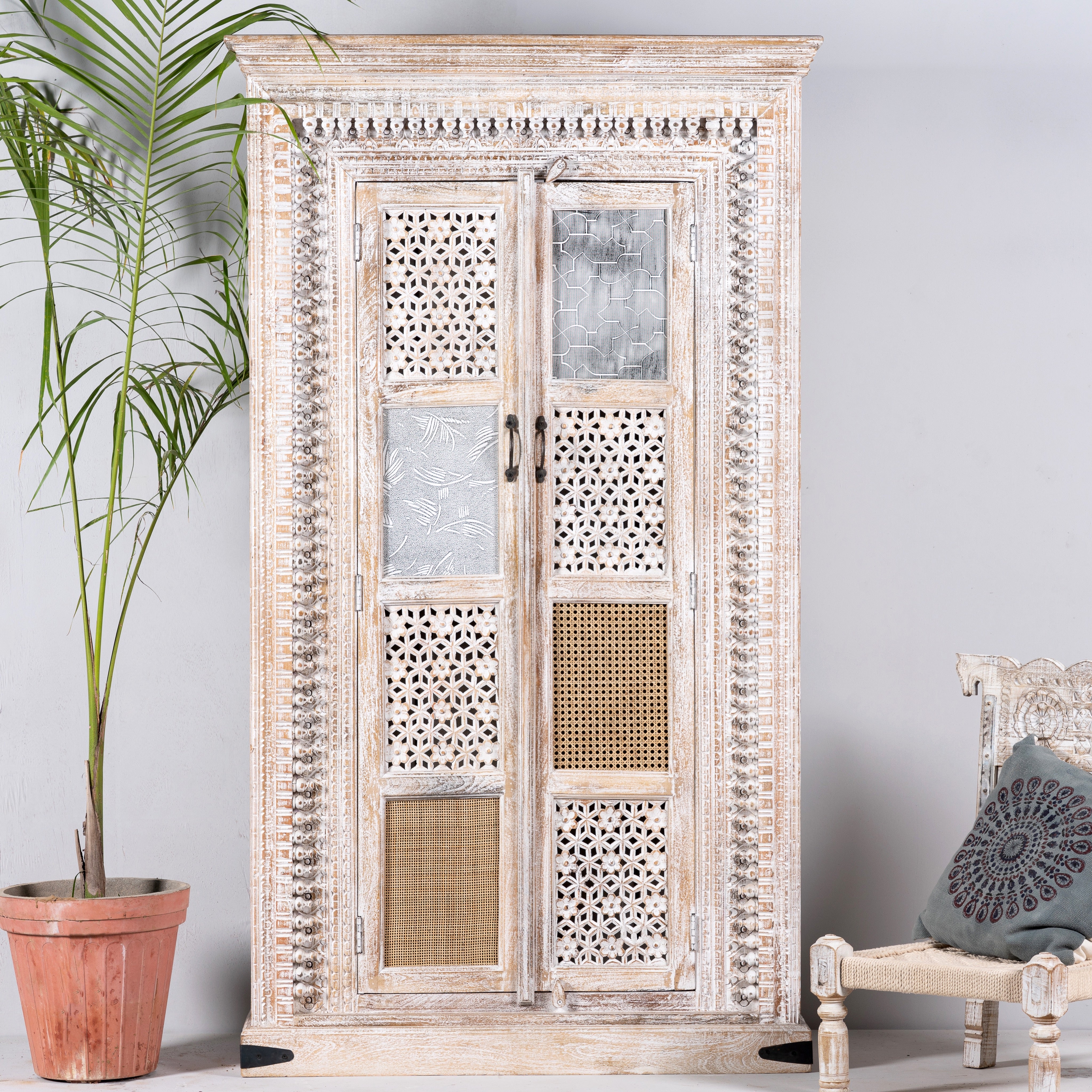 Whitewashed mango wood cabinet with hand-carved details, rattan inserts, and glass panels; versatile as bedroom furniture or wooden wardrobe; 192 × 110 × 40 cm.