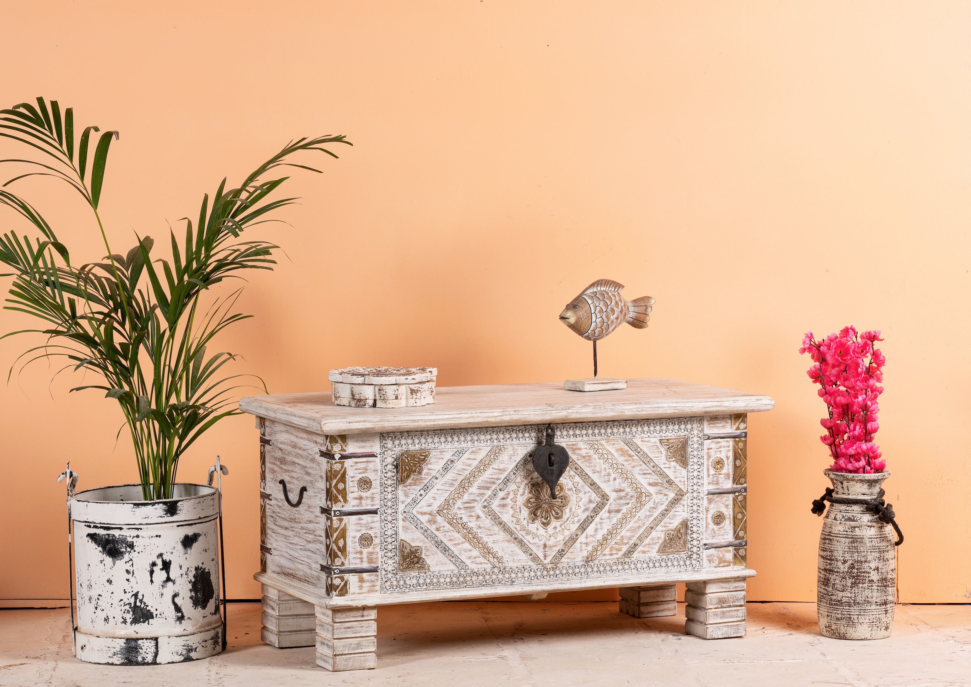Side angle image of a handcrafted mango wood chest with brass inlays and carvings – wood chest box for boho style interiors, perfect as coffee table or bedroom storage.