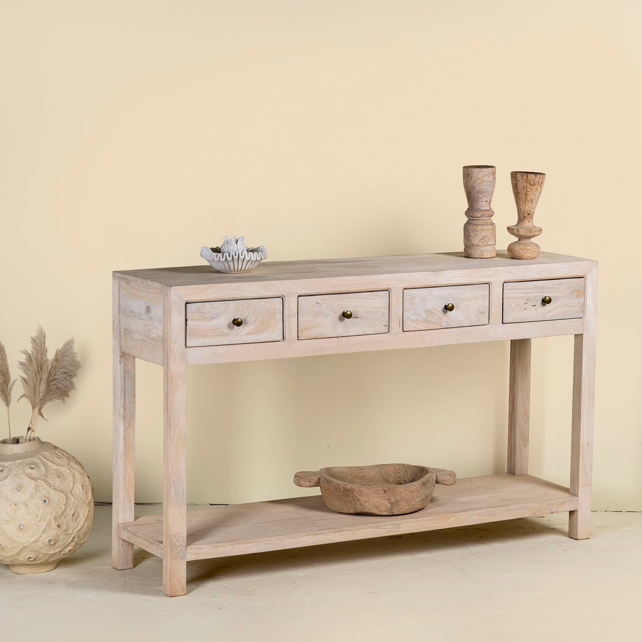 Side angle image of a sandblasted mango wood console table in Ibiza style with four drawers and lower shelf.