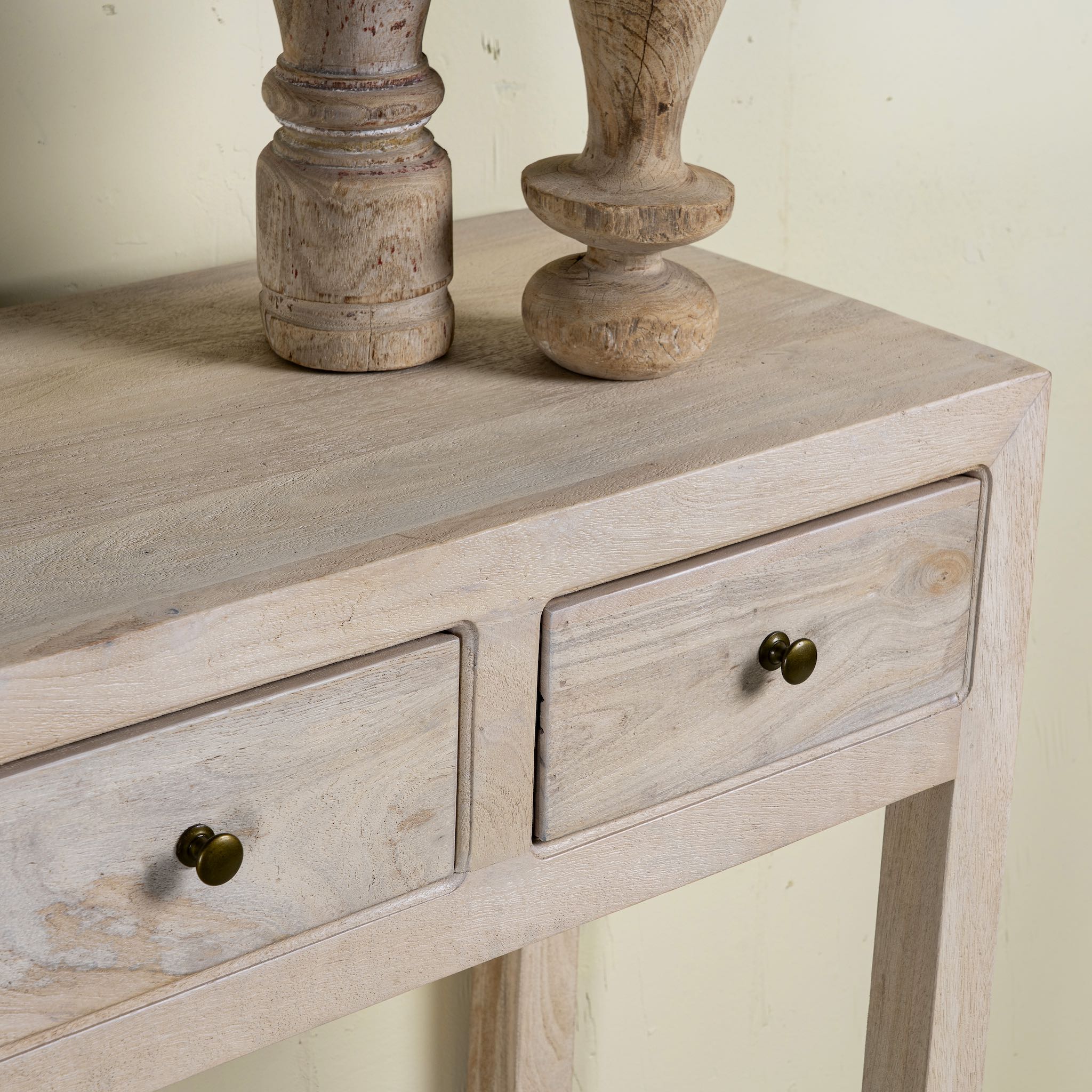 Close up image of a sandblasted mango wood console table in Ibiza style with four drawers and lower shelf.