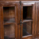 Close up image of a large reclaimed wood sideboard in rustic boho style with six glass-panelled doors, 257×46×100 cm.