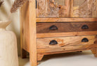 Close up image of a handcrafted mango wood cabinet Agnayi with rattan inserts and floral carvings, rattan furniture for bohemian interior, 80 × 40 × 148 cm.