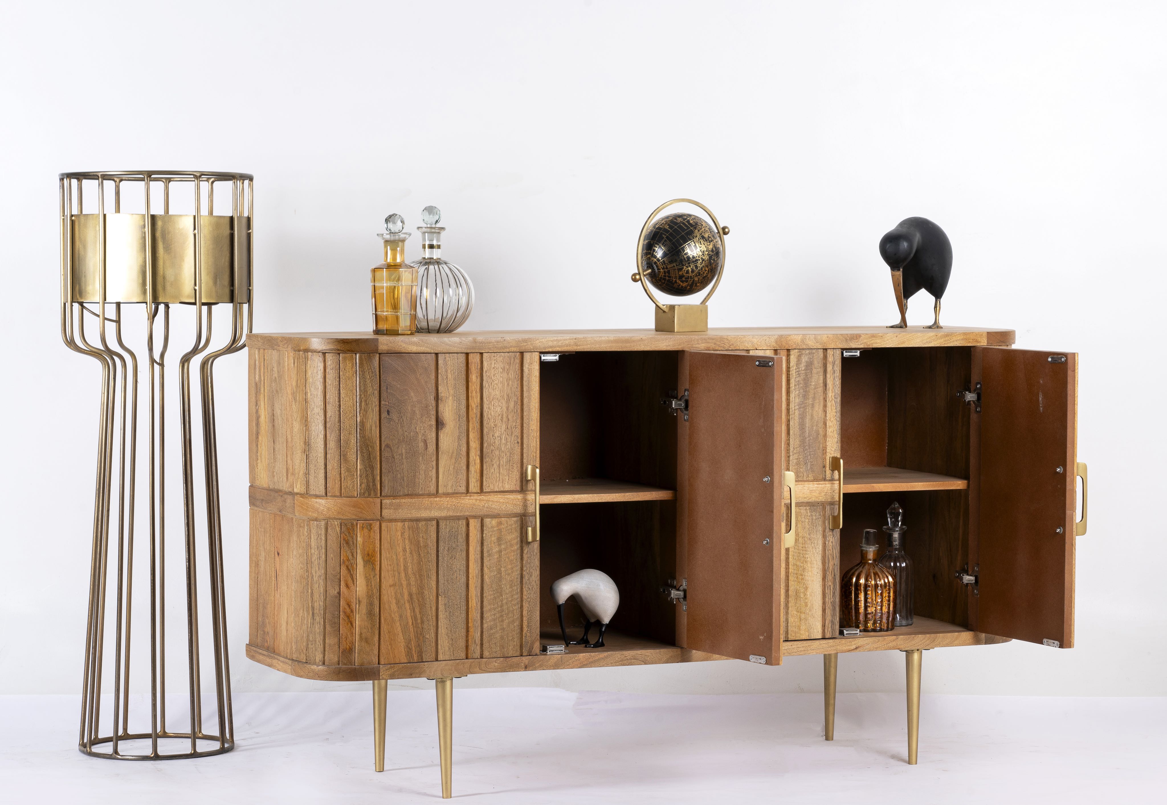 Side angle image with open door of a handcrafted mango wood sideboard with curved door panels and brass-plated legs—minimalistic style living room furniture with natural elegance.