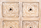 Close up image of a hand carved lowboard in mango wood, a stylish mango wood TV unit with whitewashed floral design.