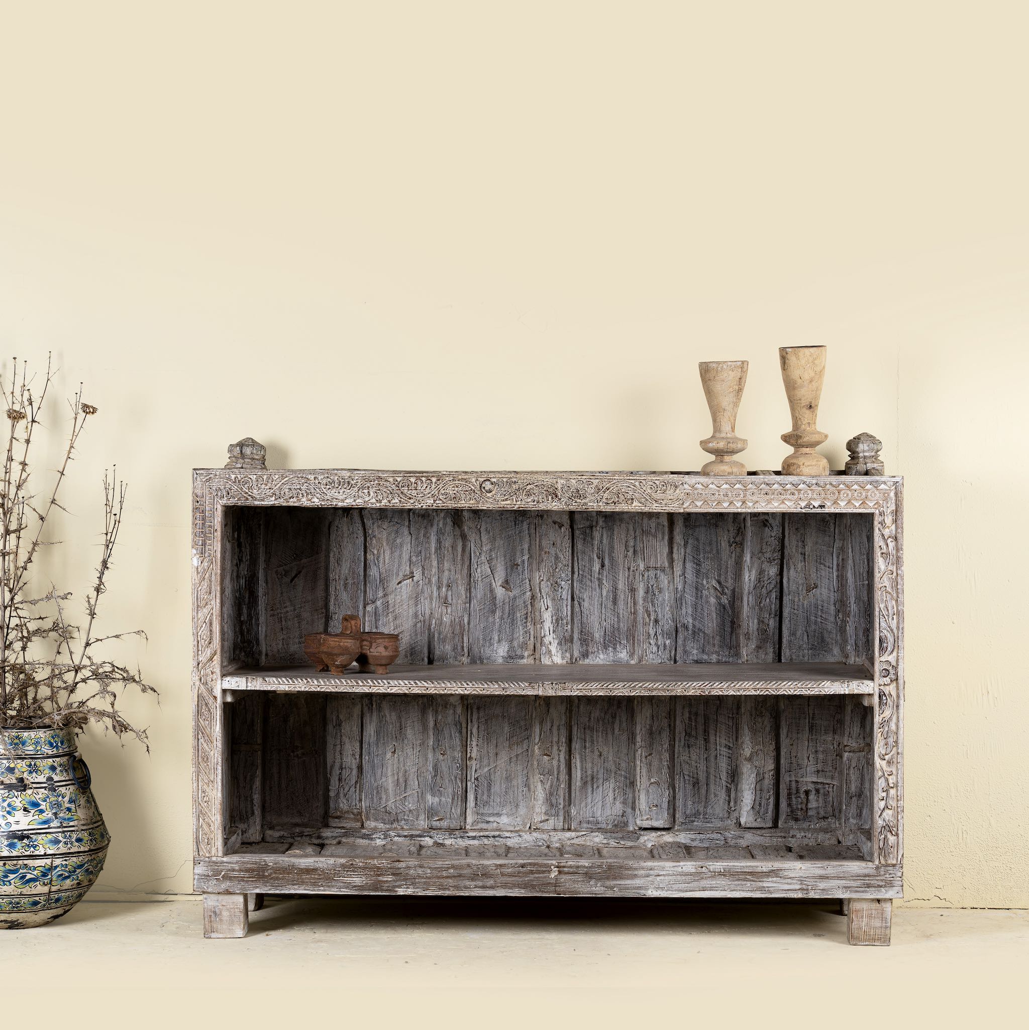 Image of the shelving space of an antique console table wood counter with open shelves, a one-of-a-kind teak piece of unique furniture.