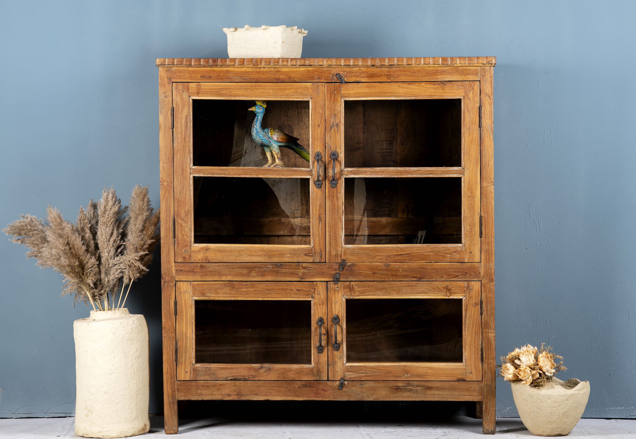 Reclaimed teak wood display cabinet with four glass-panelled doors – wooden showcase cabinet crafted as sustainable furniture with timeless appeal.