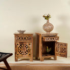 Open door picture of a pair of hand-carved bedside tables made of mango wood, featuring intricate round floral hand carvings on the doors. 
