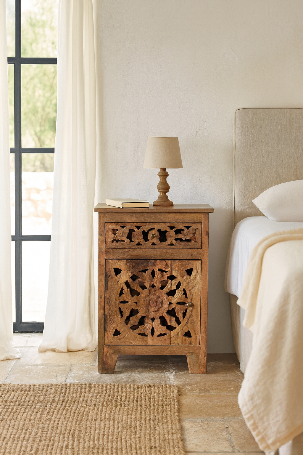 Lifestyle scene with a pair of mango wood bedside tables with floral and geometric carvings; natural finish mango wood furniture ideal for bedroom furniture, 45 × 65 × 35 cm.