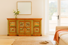Lifestyle imagination of a hand-painted reclaimed wood sideboard with Indian god motifs; unique hand painted furniture and Indian furniture online, 177 × 92 × 51 cm.