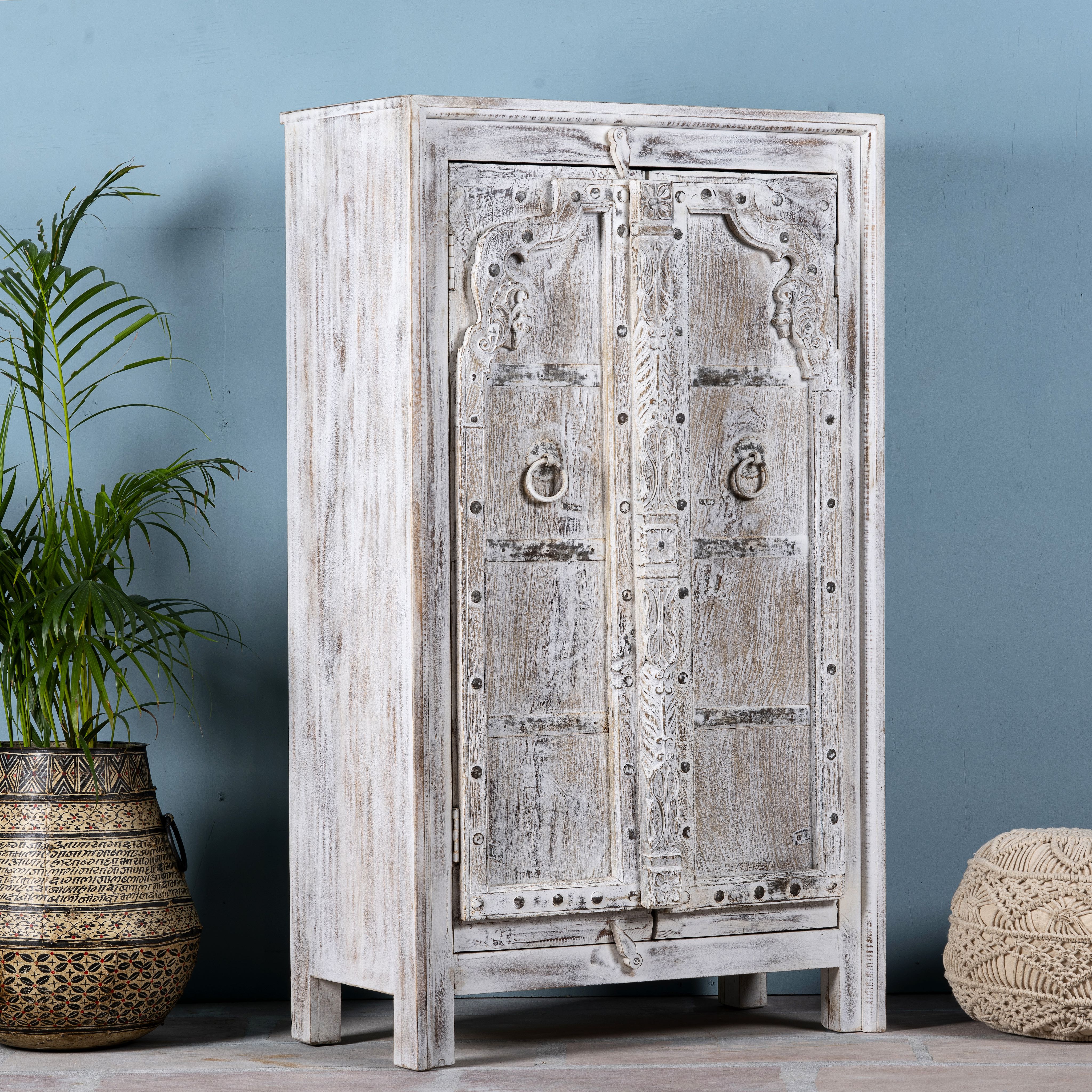 Side angle image of a handcrafted cabinet with reclaimed Indian window frame doors, white-washed finish, and iron accents – vintage home decor with teak furniture appeal.