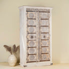 Side view of a old teak door wardrobe with floral carvings and original iron fittings.