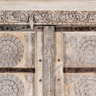 Close up picture of a old teak door wardrobe with floral carvings and original iron fittings.