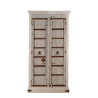 White background image of a handcrafted wooden wardrobe made from antique Indian teak doors with iron accents and floral carvings, combined with a solid mango wood body. A tall, rustic cabinet ideal for vintage-inspired or heritage-style interiors.