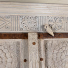 Close up image of a handcrafted wooden wardrobe made from antique Indian teak doors with iron accents and floral carvings, combined with a solid mango wood body. A tall, rustic cabinet ideal for vintage-inspired or heritage-style interiors.