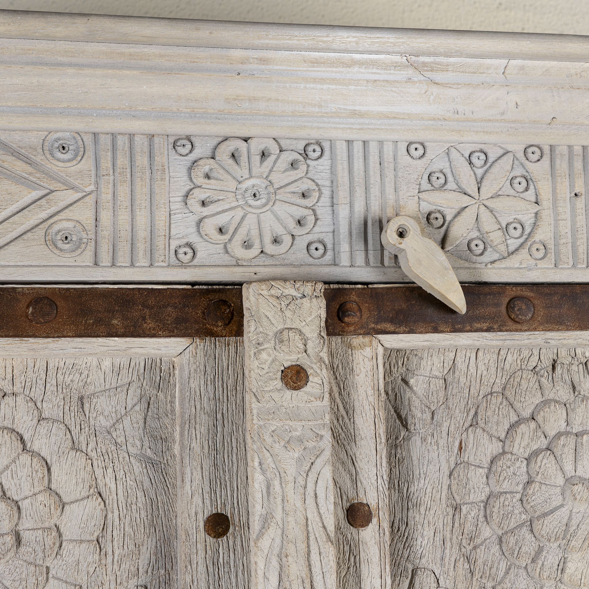 Close up image of a handcrafted wooden wardrobe made from antique Indian teak doors with iron accents and floral carvings, combined with a solid mango wood body. A tall, rustic cabinet ideal for vintage-inspired or heritage-style interiors.
