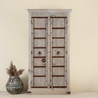 Handcrafted wooden wardrobe made from antique Indian teak doors with iron accents and floral carvings, combined with a solid mango wood body. A tall, rustic cabinet ideal for vintage-inspired or heritage-style interiors.