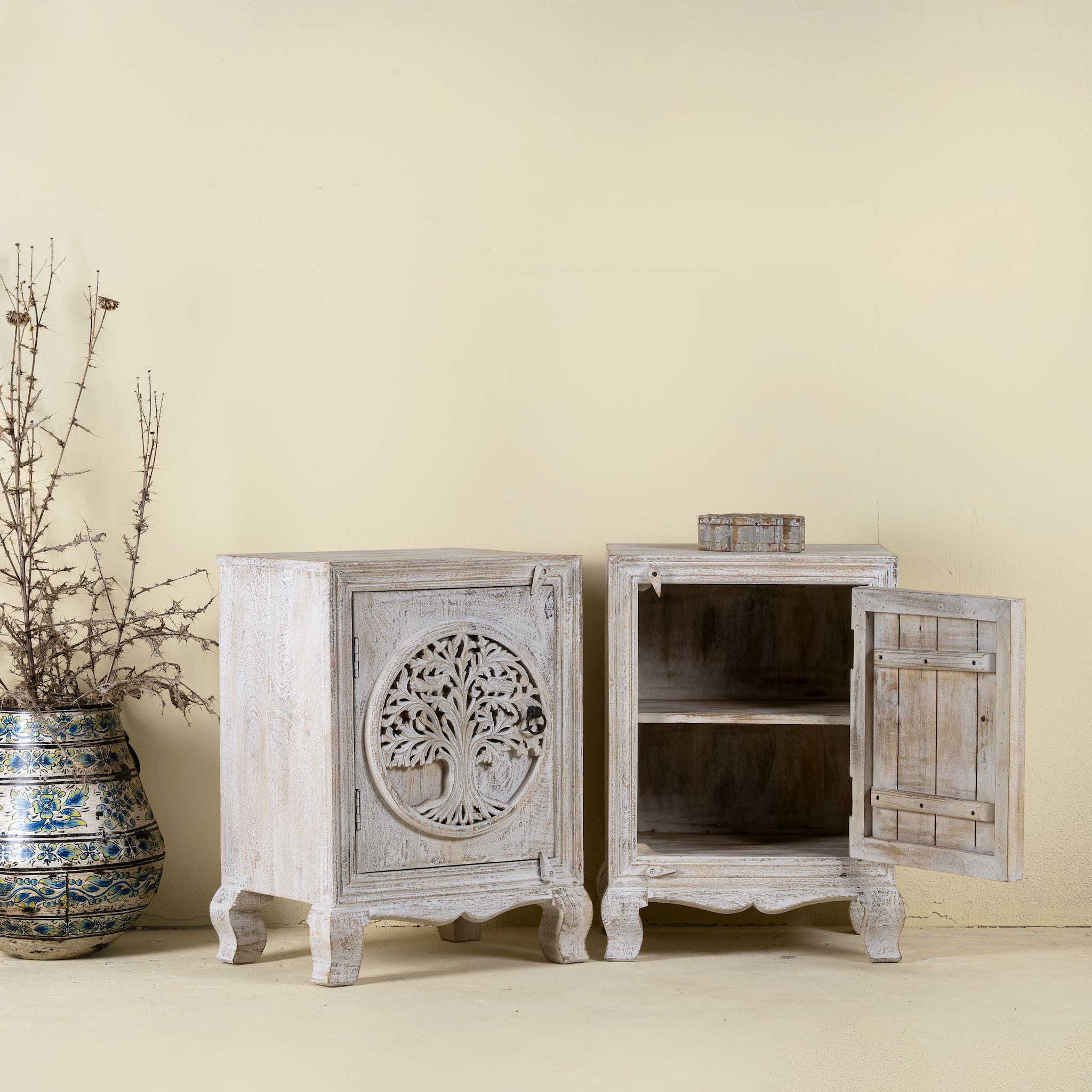 Wooden cabinet with tree of life design on a beige wall
