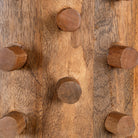 Close up image of a wooden vintage pendant lamp made from carved mango wood with tree design and brass-plated hanging – a unique piece of mango wood lighting for dining rooms, living spaces, or entryways.