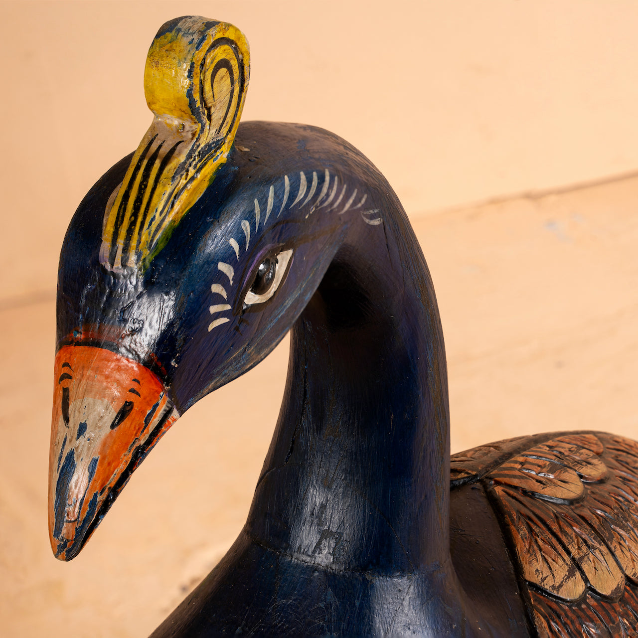 Close up image of a hand-painted mango wood peacock decor – Indian home accessory from Rajasthan, ideal for vintage home decor and artistic interiors.