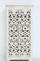 White background image of a hand-carved mango wood cabinet with floral and geometric motifs in white-washed finish – carved wooden furniture with Mediterranean-inspired design.
