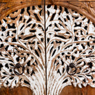 Close up image of a mango wood cupboard with hand carvings in tree of life design.
