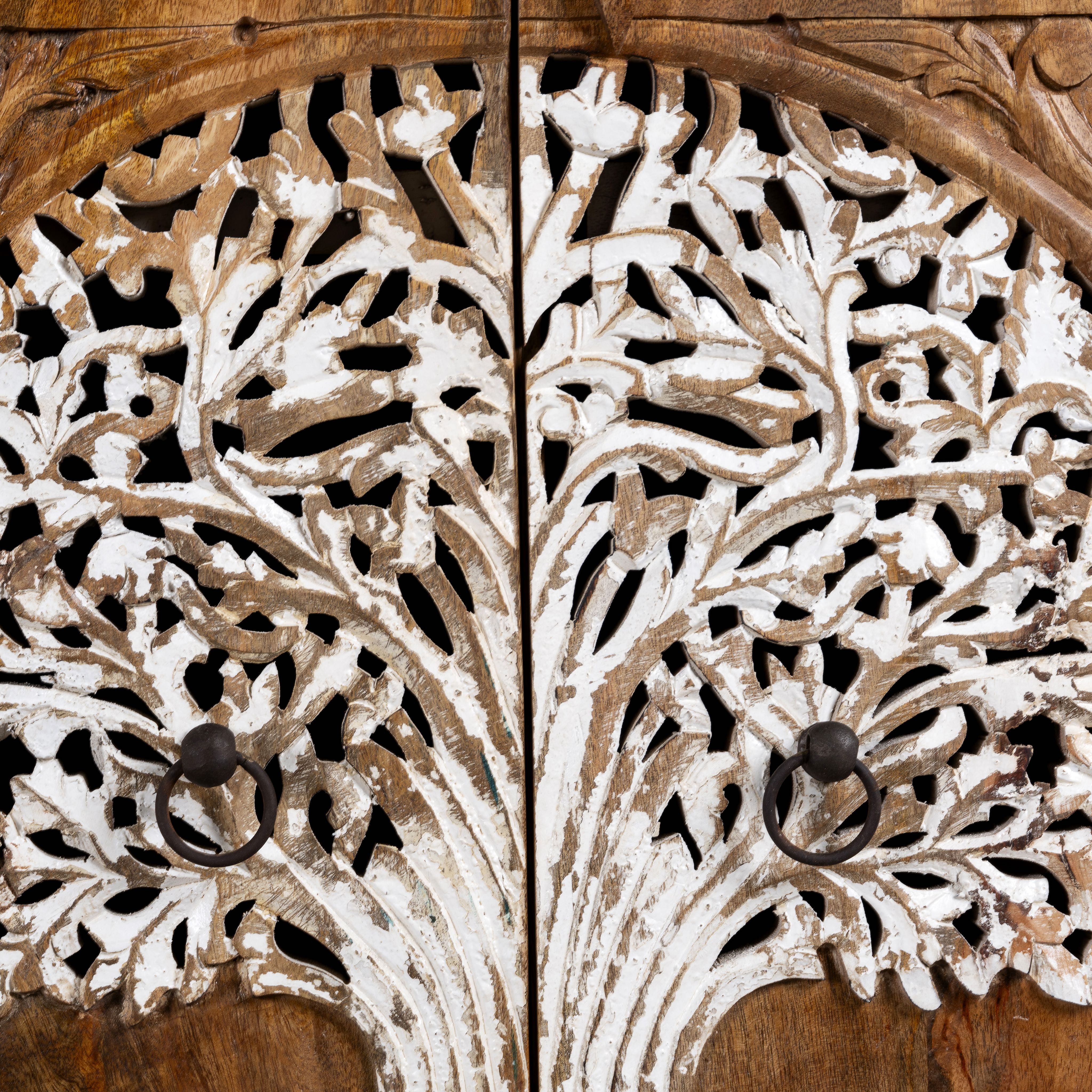 Close up image of a mango wood cupboard with hand carvings in tree of life design.