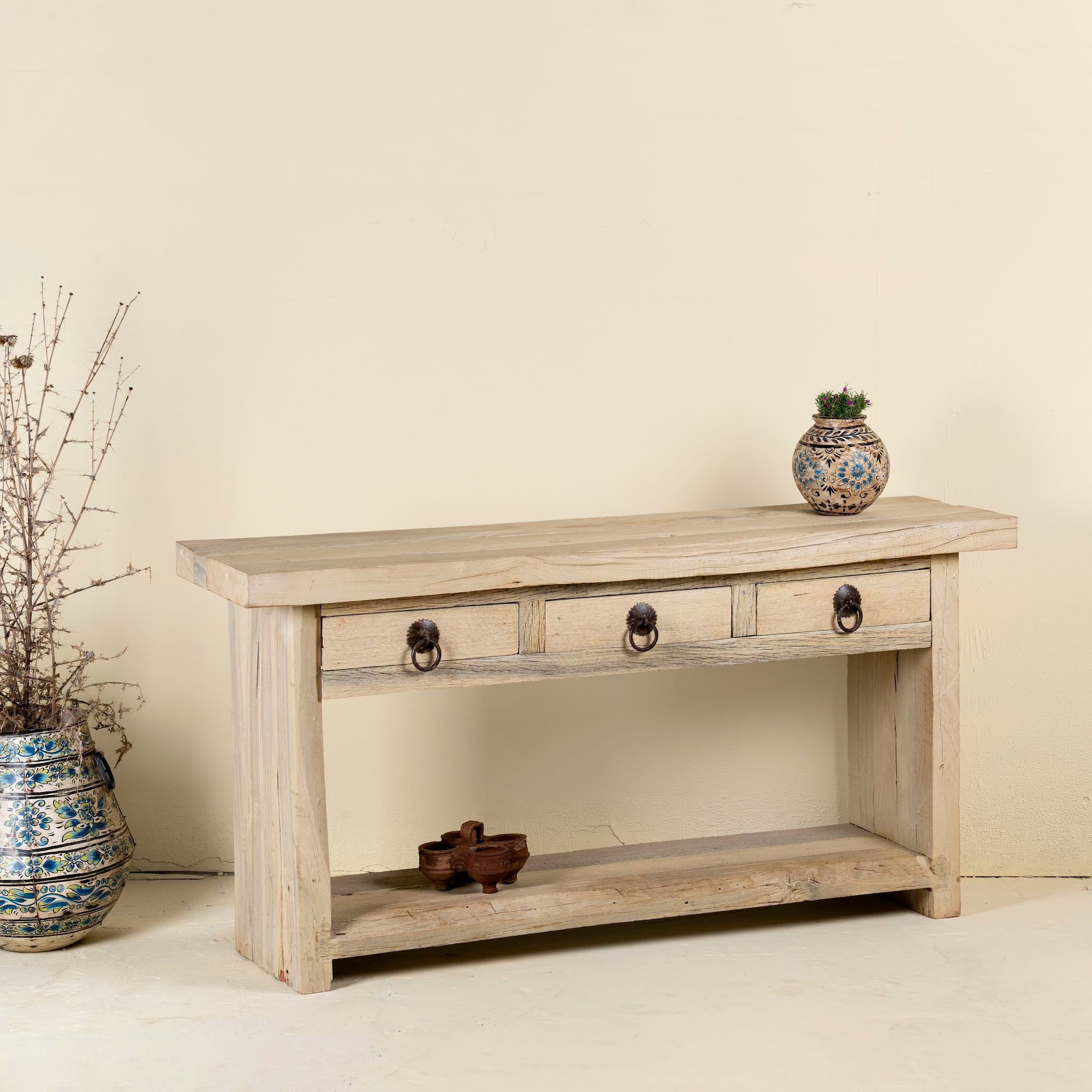 Side angle image of a Ibiza style reclaimed teak console table with sandblasted finish, three drawers, and lower shelf, versatile as bathroom furniture or hallway console.