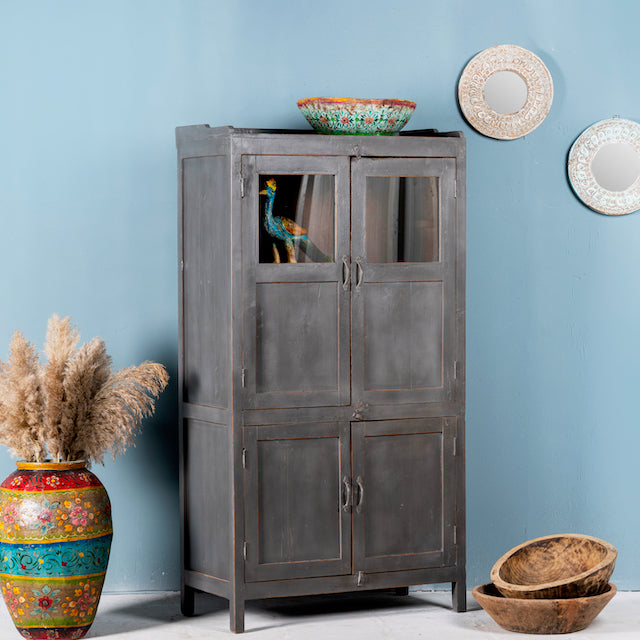 Side angle image of a shabby chic teak wood cabinet with glass doors and natural reclaimed finish – sustainable furniture ideal for vintage-style dining and living spaces.