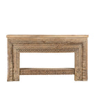 White background image of a ornate console table crafted from reclaimed teak wood and refurbished architectural elements, featuring intricate hand-carved detailing with floral and geometric motifs, showcasing a vintage artisanal aesthetic.
