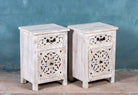Side angle image of a Whitewashed nightstand made of mango wood with Mediterranean-style carved detailing and one drawer – Gagan bedside table by Om Home & Garden