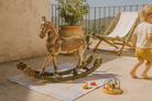 Lifestyle image of a hand-painted mango wood rocking horse “Gita” in Rajasthani style – colourful Indian home accessory and mango wood decor piece, 104x78x30cm.