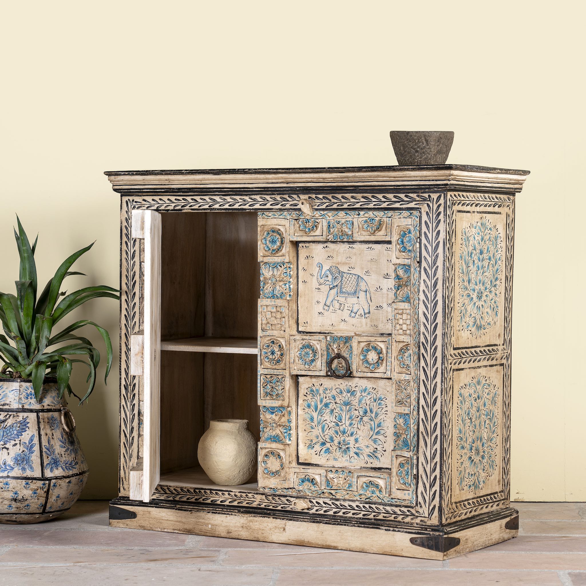Side angle image with open door of a hand-painted cupboard made from reclaimed wood and old Indian doors – a sustainable furniture piece perfect for Indian home decor and rustic interiors.