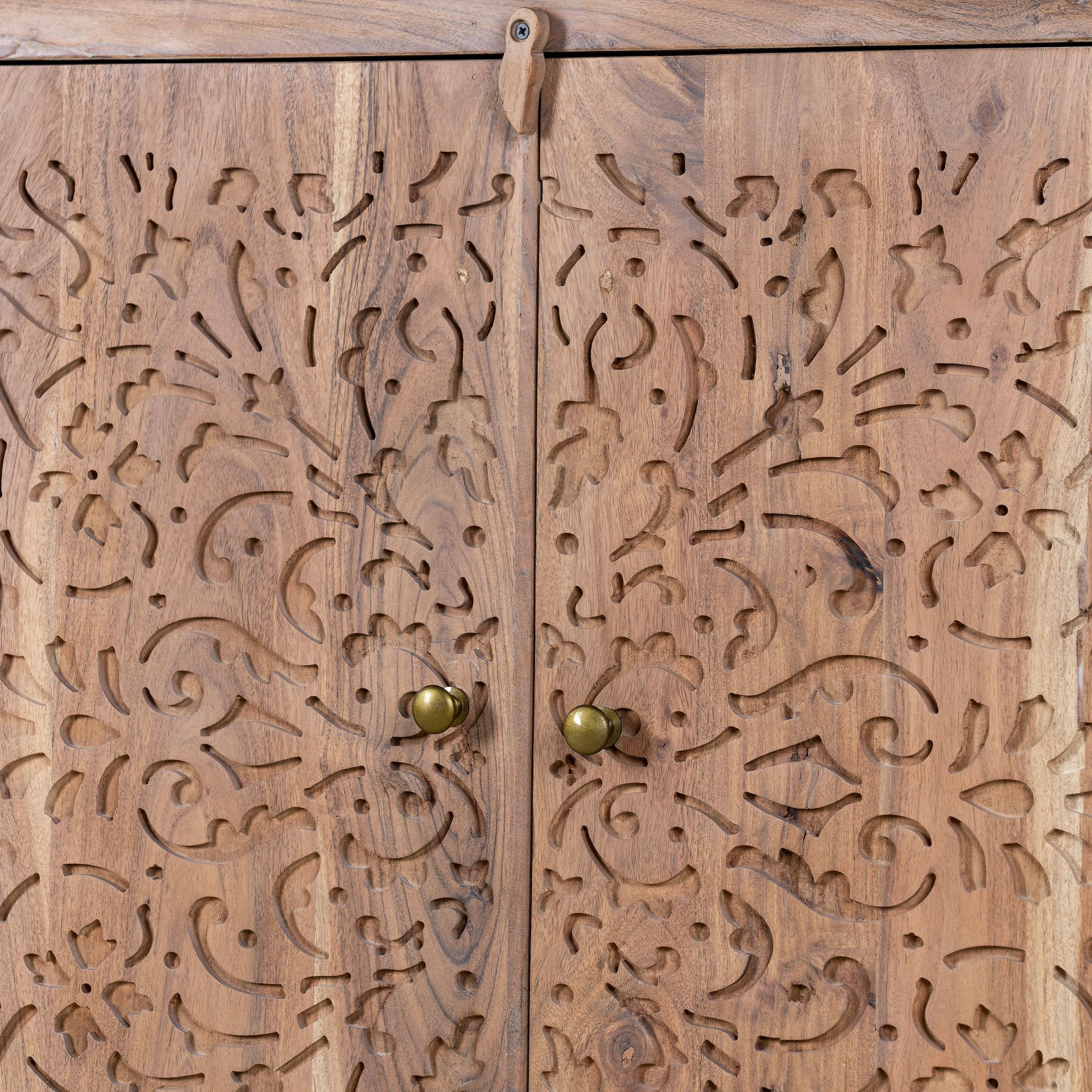 Close up picture of a Cupboard with floral carvings over both doors made of acacia wood in a living room scene.