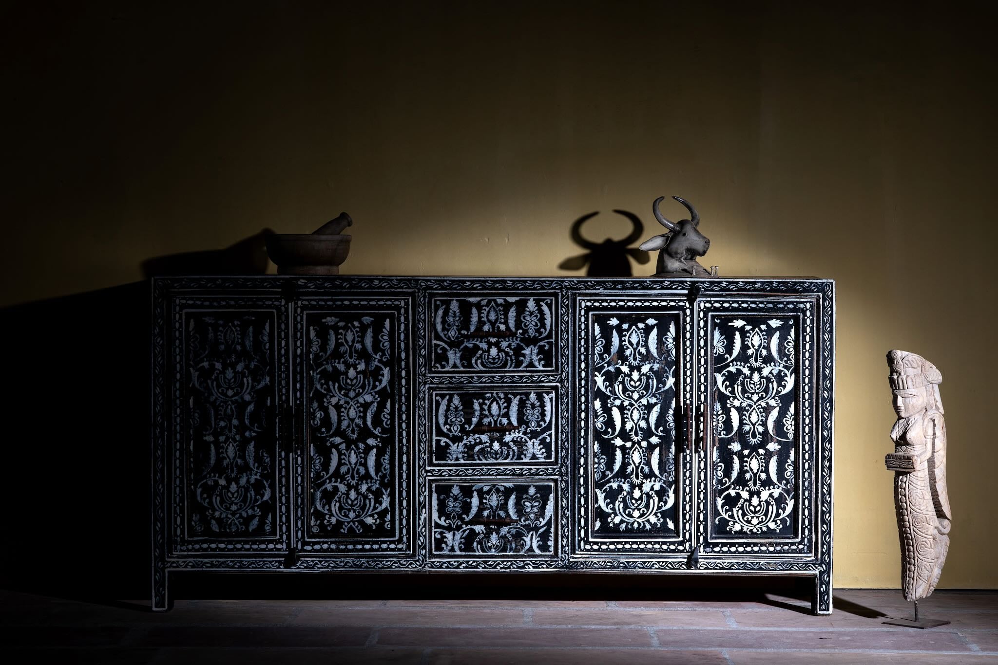 Lifestyle image of a hand-painted black and white sideboard made of reclaimed wood – Kaira model by Om Home & Garden