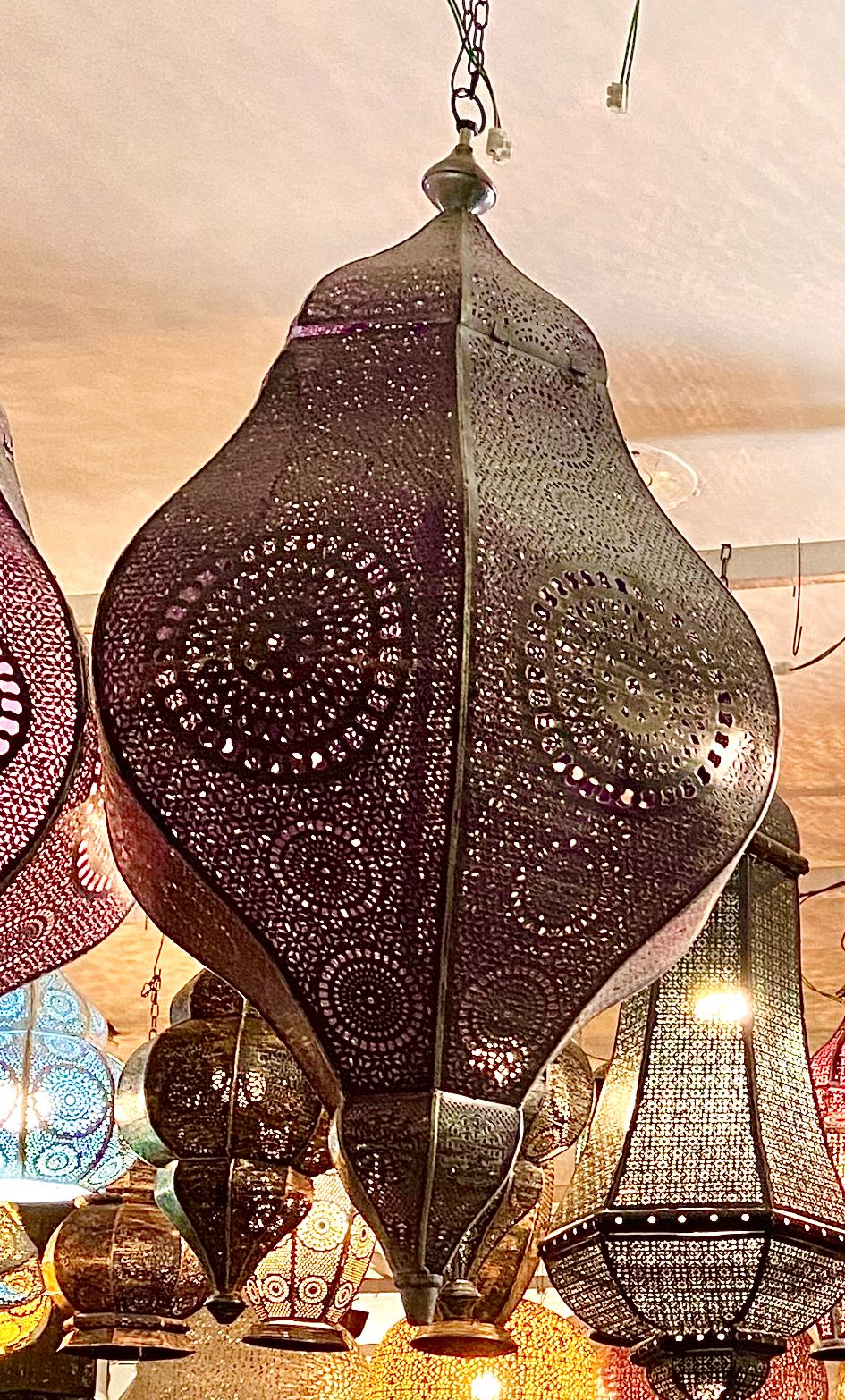 Decorative hanging lanterns with intricate designs in a warm indoor setting.