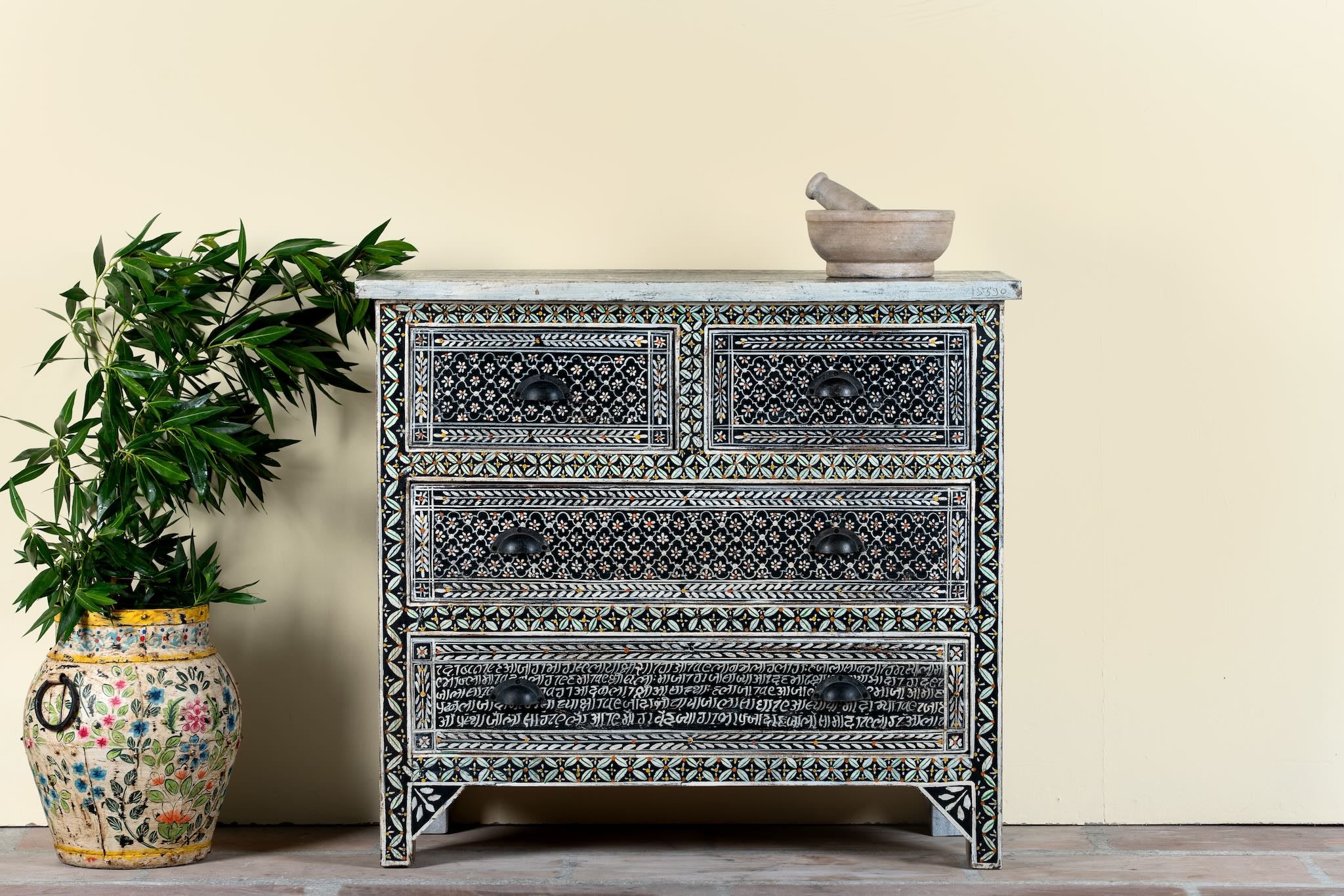 Lifestyle image of a hand-painted Indian chest of drawers made from recycled wood – unique furniture featuring colourful motifs and antique craftsmanship.